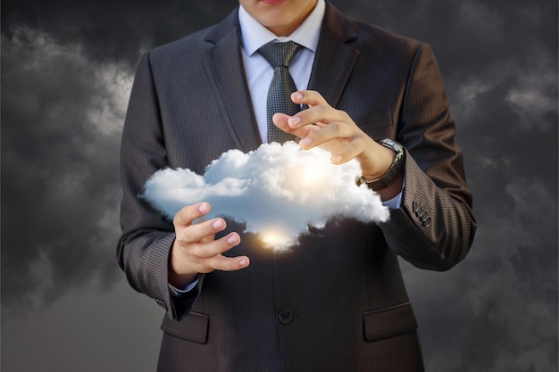 A man in a suit holds a cloud in his hands.