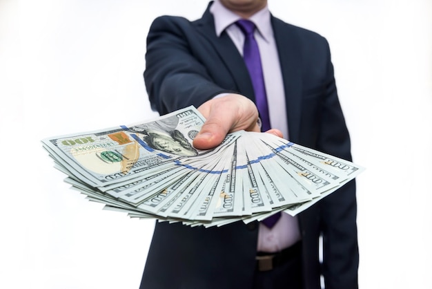 Man in suit offering dollar banknotes close up