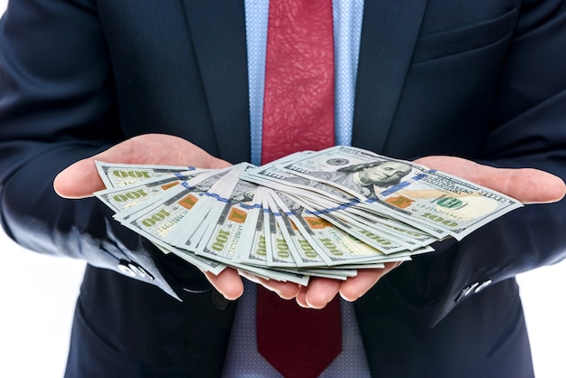 Man in suit offering dollar banknotes close up