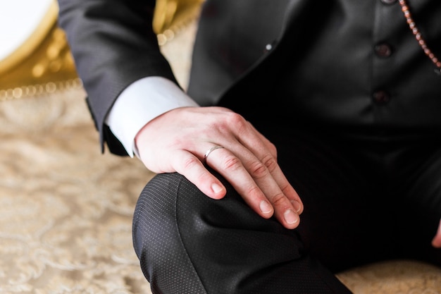 Man in suit put his hand on his knee