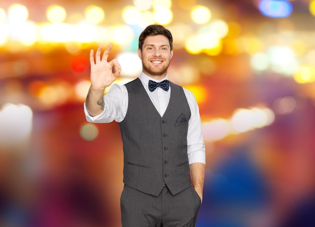Photo man in suit showing ok sign over night city lights