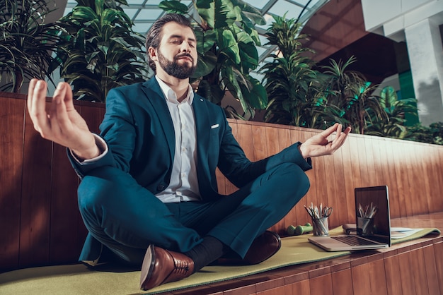 Photo man in suit sits and meditates.