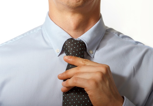 Man in suit straightens tie close up, front view