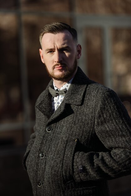 Photo man in a suit and sweater poses on the street