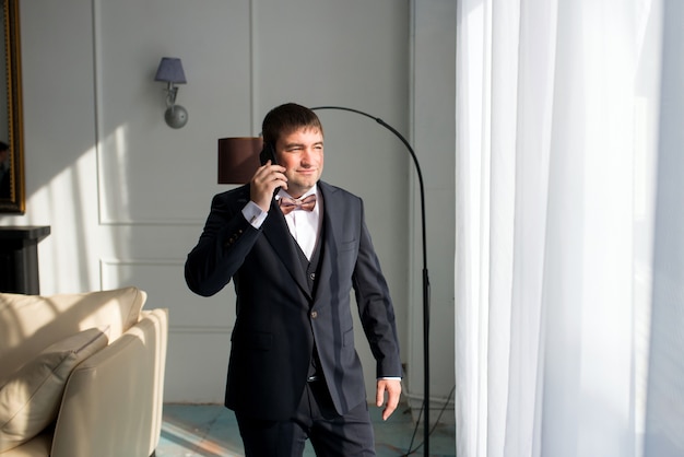 A man in a suit talking on the phone at the hotel