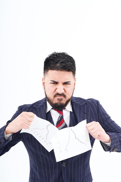 A man in a suit tearing up materials