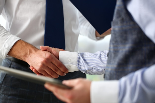 Man in suit and tie give hand as hello in office