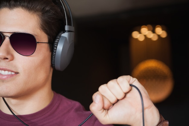 Man in sunglasses listening to music with headphone