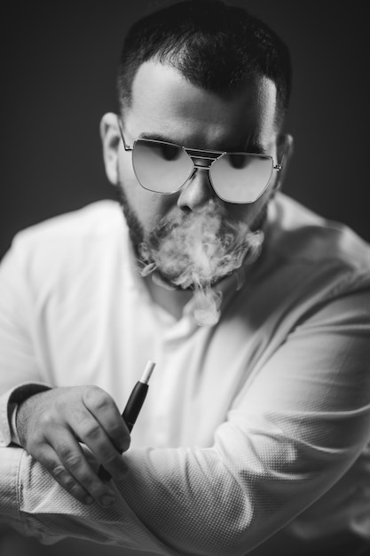 Man in sunglasses and white shirt smoking