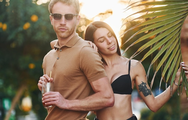 Uomo in occhiali da sole donna in reggiseno nero felice giovane coppia è insieme in vacanza all'aperto durante il giorno soleggiato