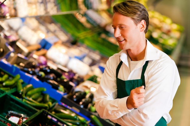 Uomo in un supermercato come commesso