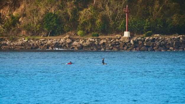 Man on a surfboard in the middle of the sea waiting for a wave