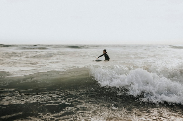 Man surfen op het strand