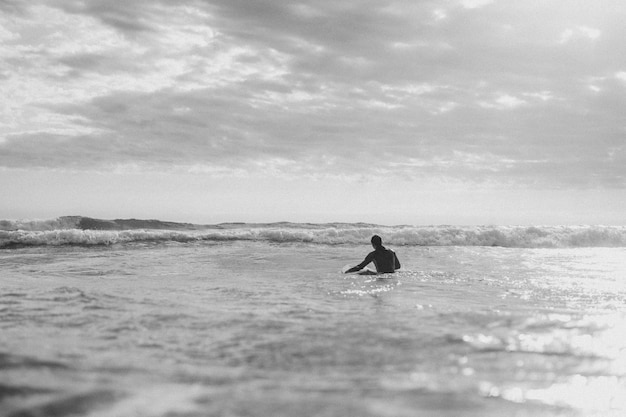 Uomo che fa surf in spiaggia