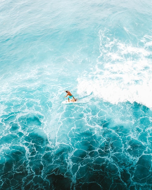 Photo man surfing on blue sea water