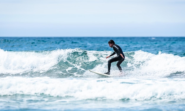 写真 空に逆らって海でサーフィンをする男