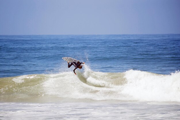 Photo man surfing at sea against clear sky