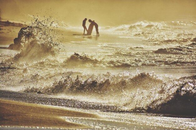 空に逆らって海でサーフィンをする男