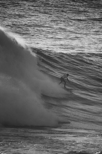 Foto uomo che fa surf sulle onde del mare