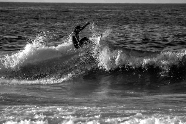 Foto uomo che fa surf sul mare