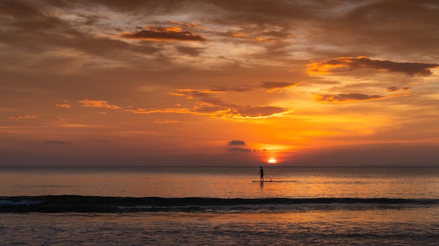 Photo man surfing in the summer sunset