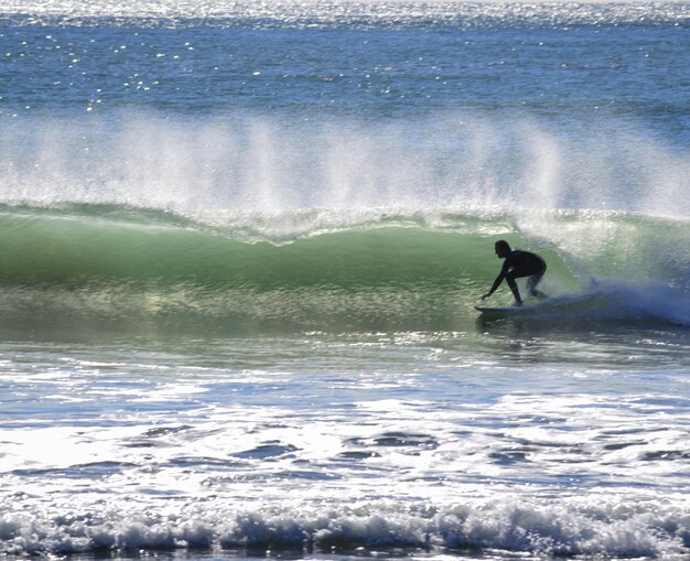 Foto man surft in de zee tegen de lucht in de winter