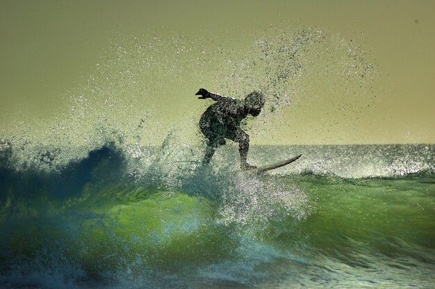 Foto man surft in de zee tegen de lucht