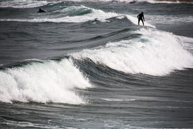 Foto man surft in de zee