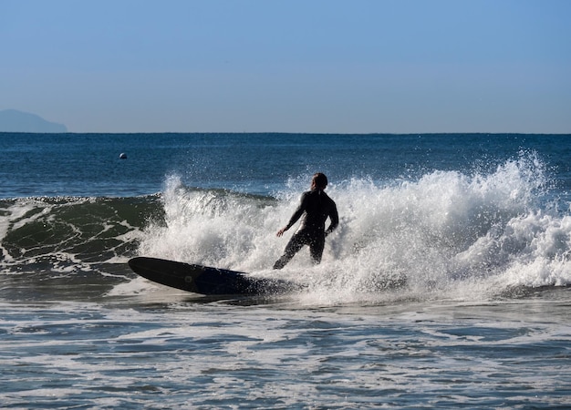 Foto man surft in grote golven bij de kust.