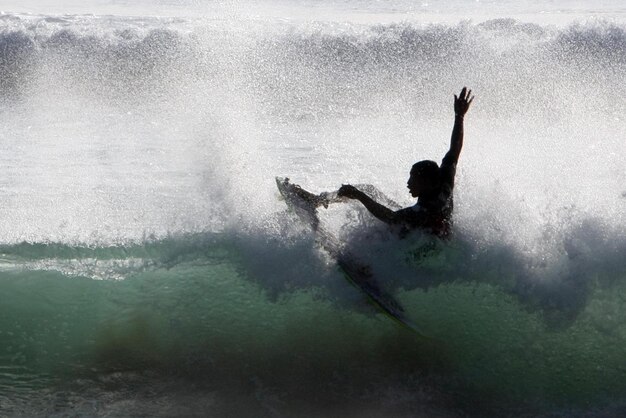 Foto man surft op golven op zee