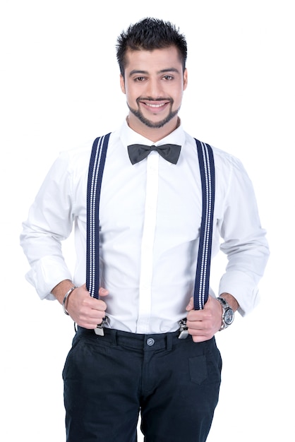 Man in suspenders and butterflies smiling at camera.