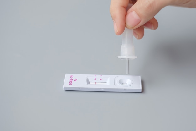 Rapid Antigen Test kit에 의한 면봉 COVID-19 테스트. 코로나바이러스 자가 비강 또는 가정 테스트, 잠금 및 가정 격리 개념