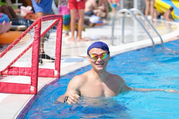 Man in swimming goggles and cap playing water polo