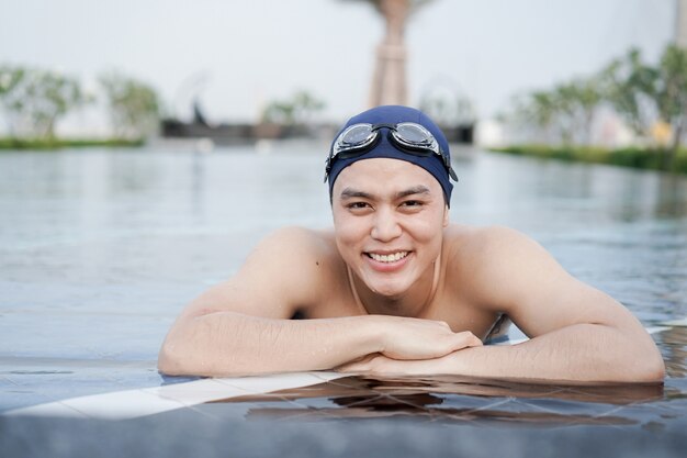 Uomo in piscina sorridente dopo l'esercizio finito