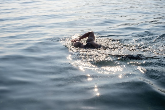 мужчина плавает в море. человек, купающийся в море или озере.