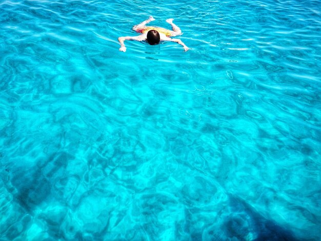 Man swimming in sea on sunny day