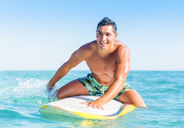 Man swimming over surfboard in the water surfing surf beach\
surfer weekend water