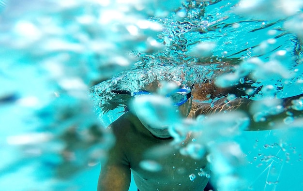 Foto uomo che nuota sott'acqua in piscina