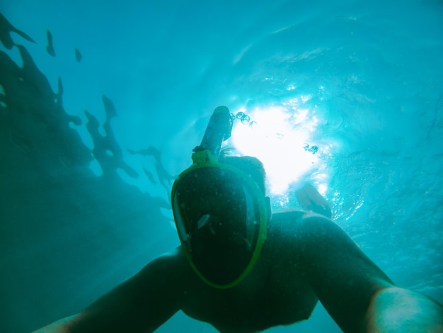 Man swimming underwater with snorkeling musk