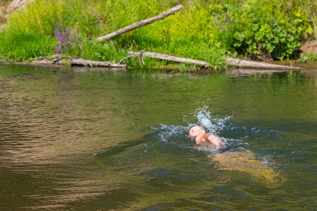 A man swims in a wild river with the current Adventure traveling lifestyle Concept wanderlust Active weekend vacations wild nature outdoor