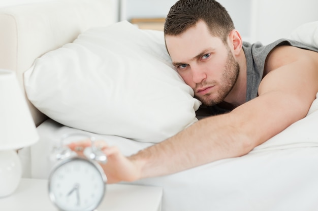 Man switching off his alarm clock