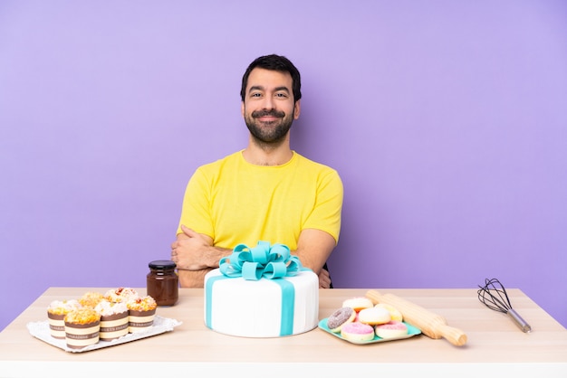 Uomo in una tabella con una grande risata della torta