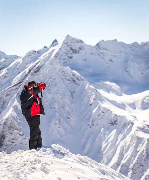 Man tacking picture high up in the mountains