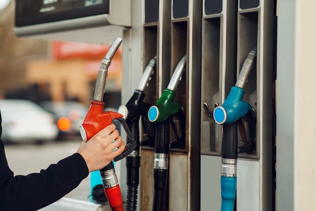 L'uomo prende la pistola sulla stazione di servizio, vista del primo piano, concetto di riempimento del carburante. servizio di rifornimento benzina, benzina o gasolio