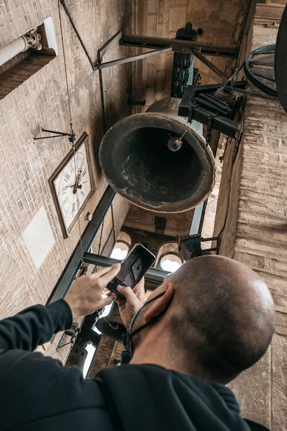 A man takes picture of bell of girlada in cathedral of Seville