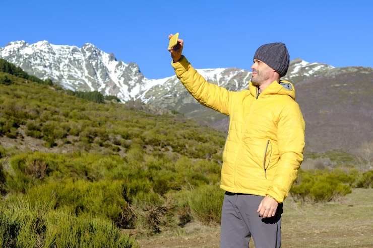 Photo a man takes a selfie with his smartphone in the snowy mountains enjoying nature alone         person