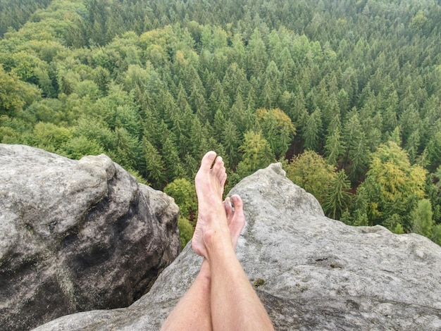 写真 自然の中で休憩をとり山頂から遠くの風景を見下ろす男性