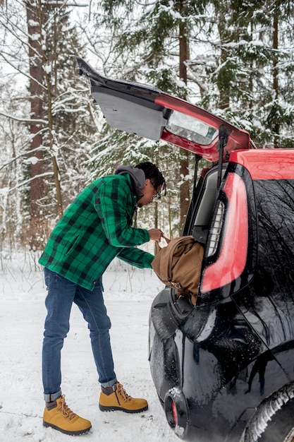 写真 車からバックパックを取る男