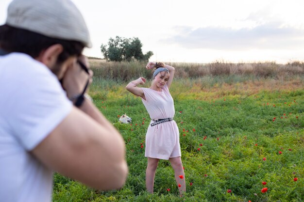 Foto uomo che cattura foto con la fotocamera di una donna nel campo