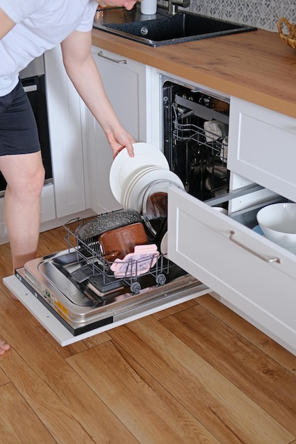 Man taking clean dishes out of dishwasher